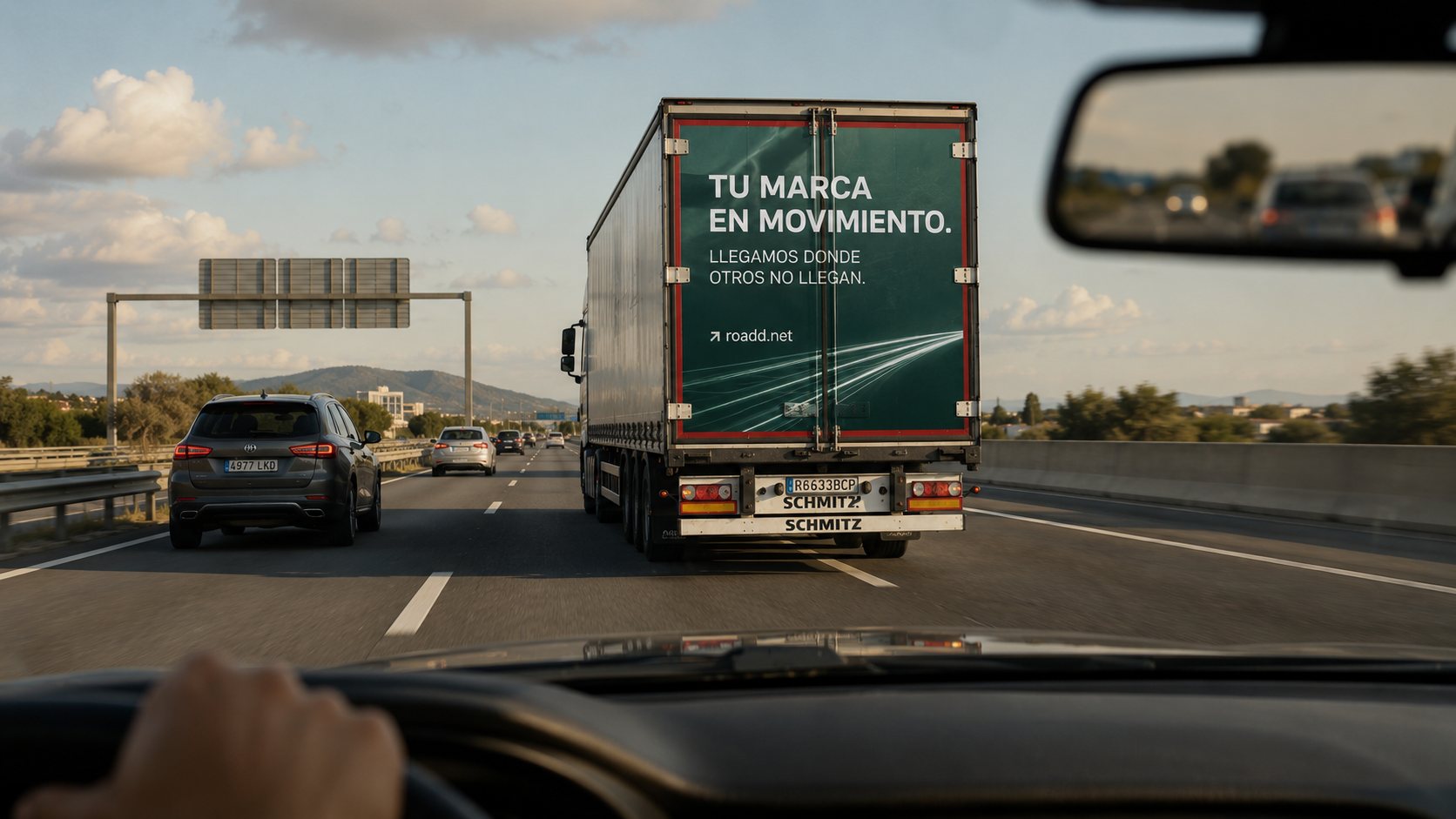 Vista desde un vehículo en autovía, con un tráiler publicitario delante